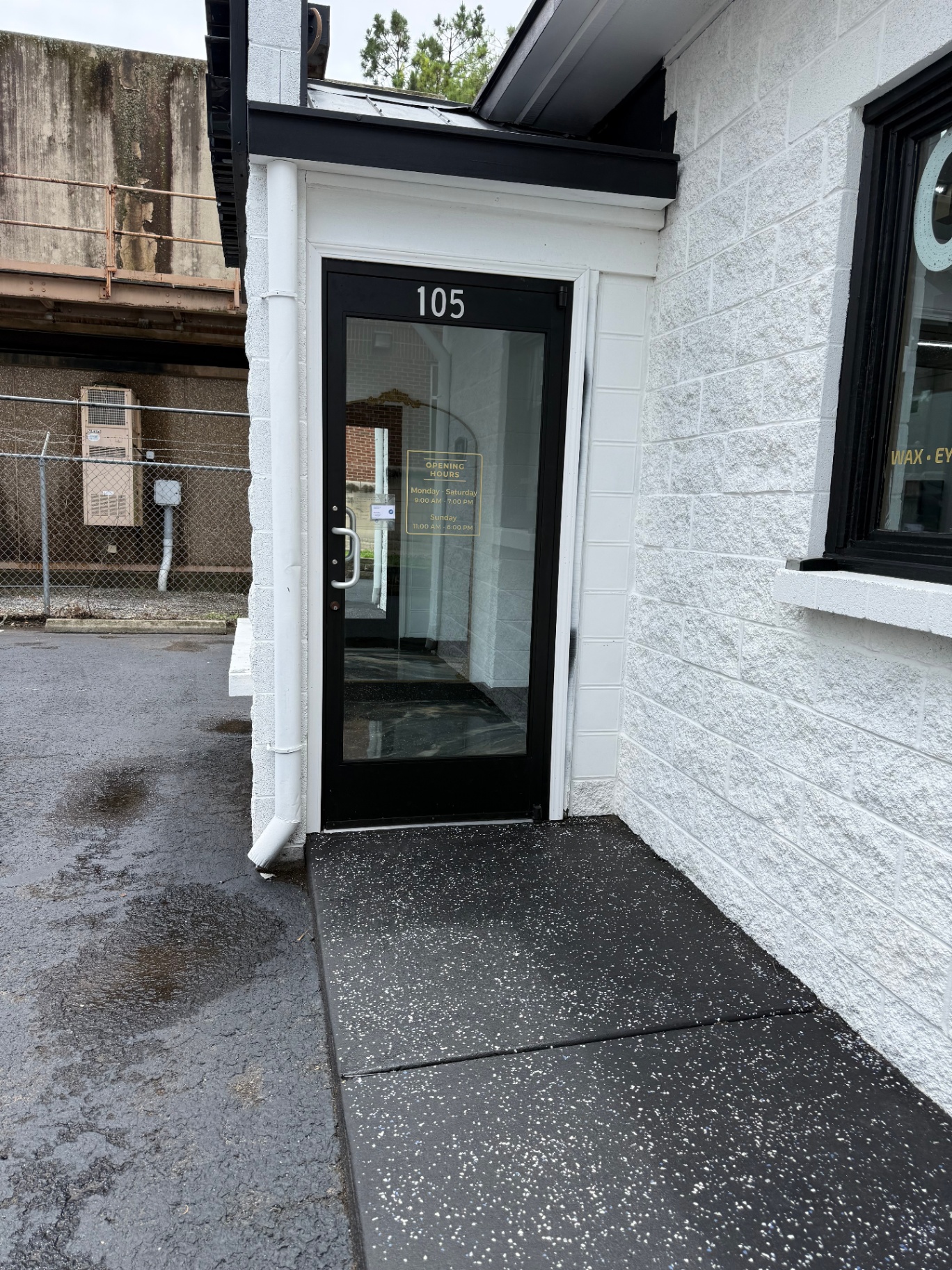 Front entrance of Queen Salon & Beauty with posted opening hours