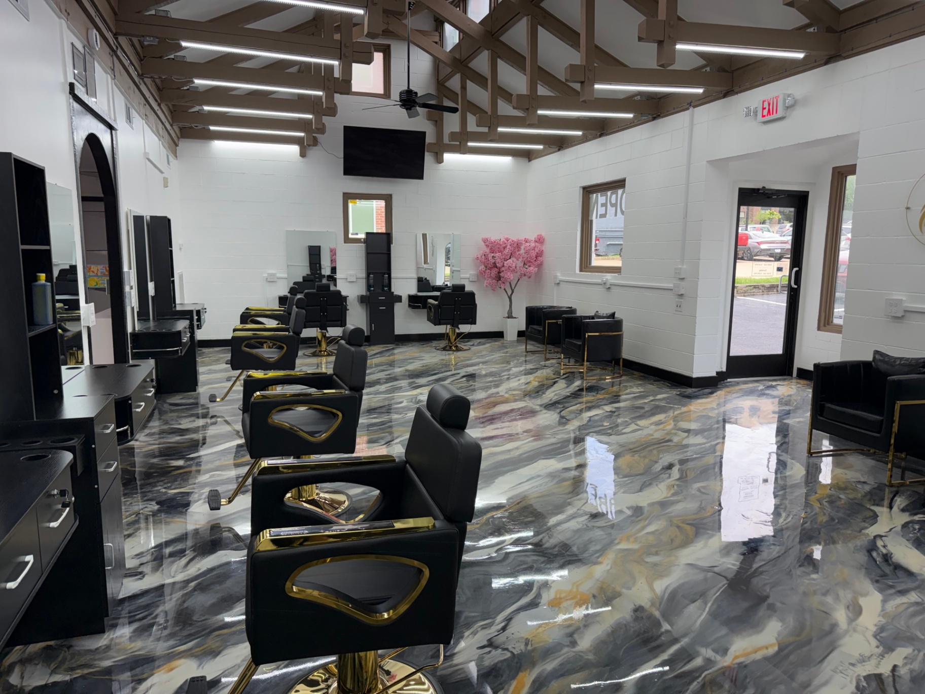 Salon floor with gold accented chairs and vaulted wood ceiling