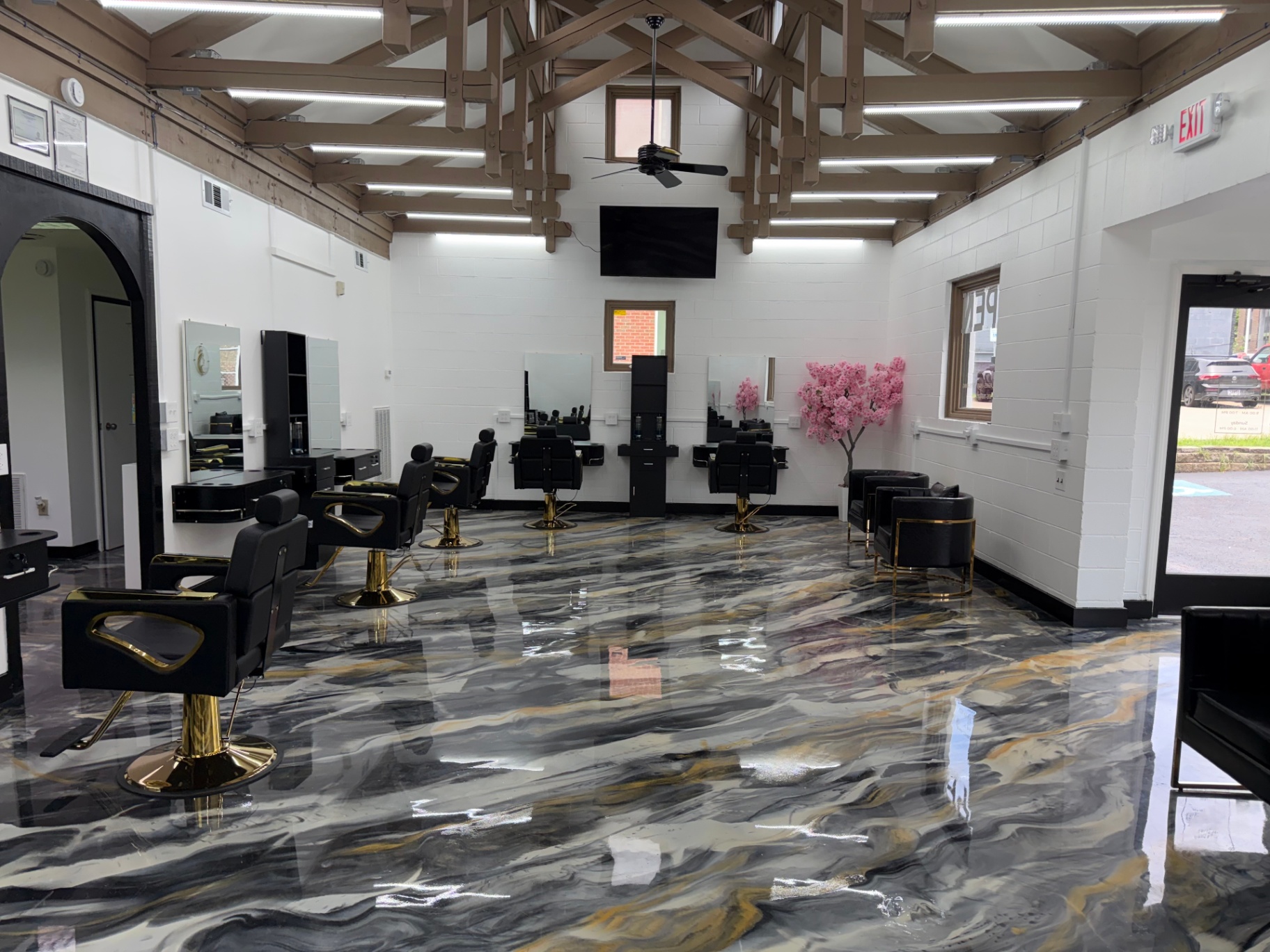Interior of Queen Salon & Beauty showing styling stations, gold accents, and marbled floor